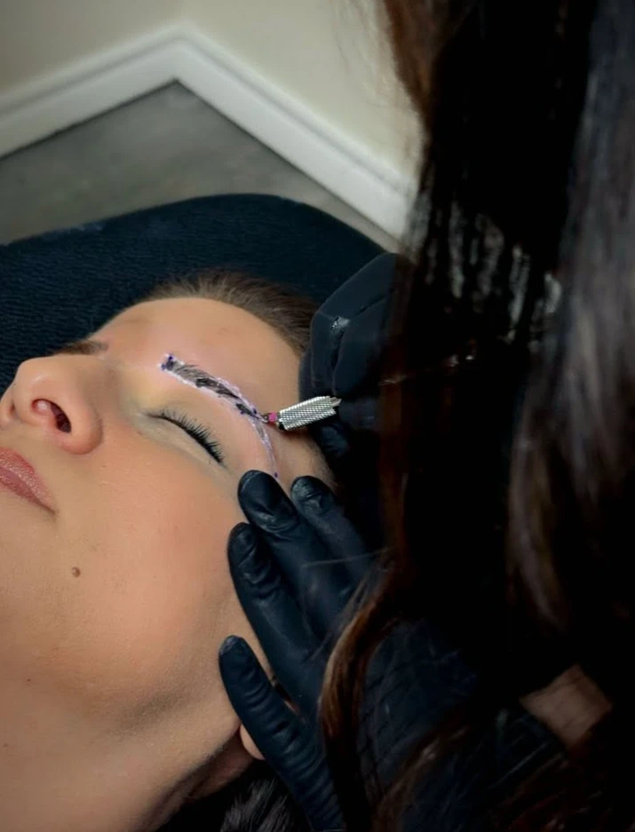 Microblading eyebrows in progress with a hand tool
