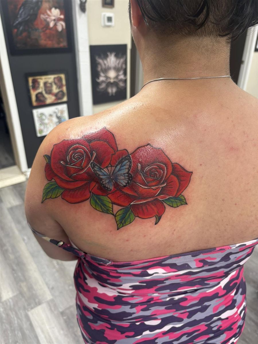 Bold red rose and blue butterfly color tattoo on the shoulder blade
