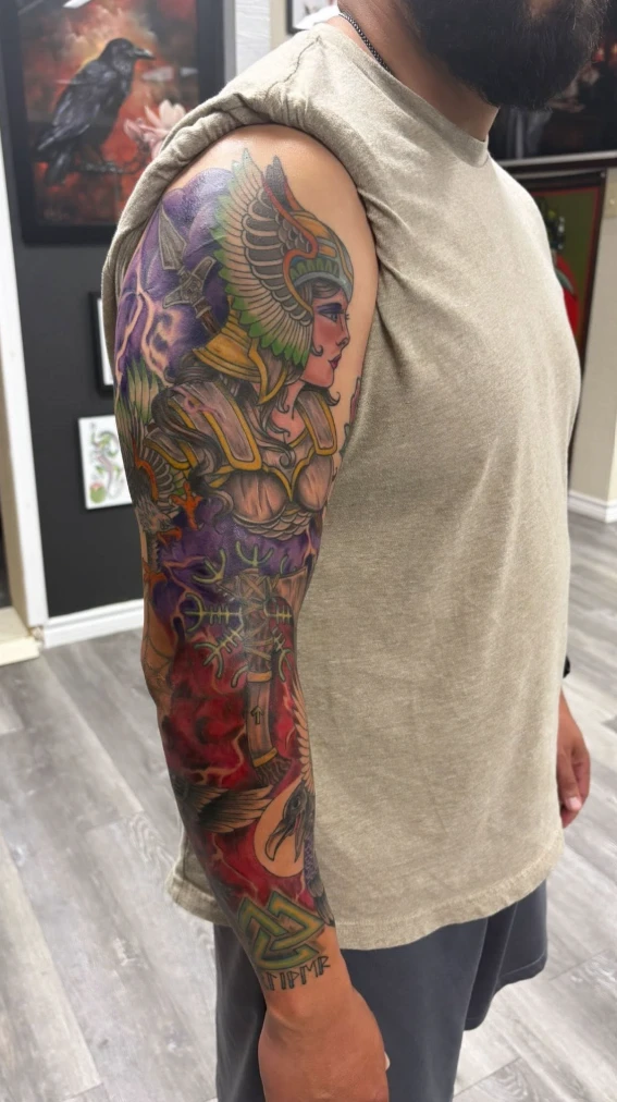 Color full sleeve tattoo with winged Valkyrie warrior, Norse runes, ravens and Valknut, tattooed in Glen Rose TX