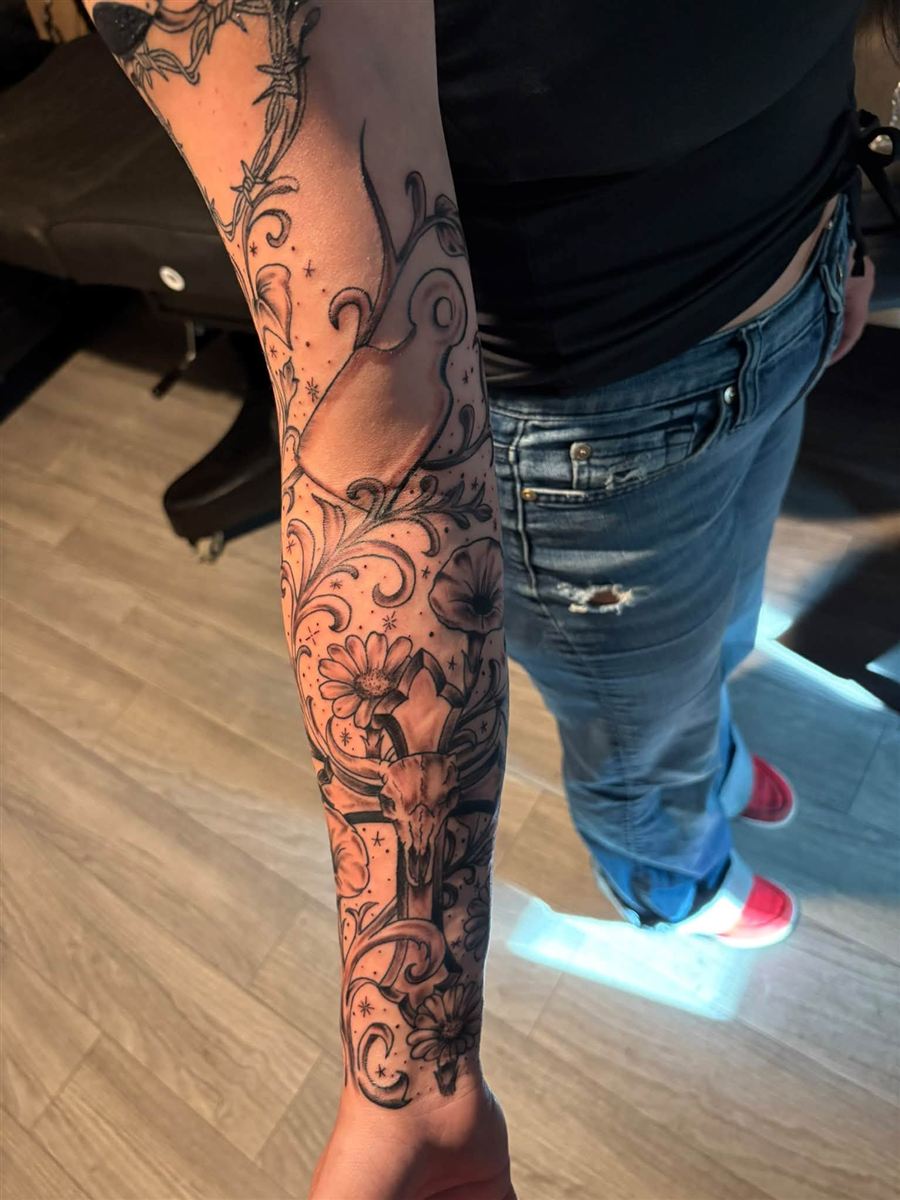 Black and grey western forearm sleeve with longhorn skull, daisies and filigree scrollwork